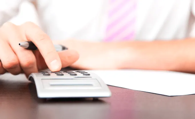 Conseiller funéraire calculant un devis personnalisé avec calculatrice pour assurance obsèques